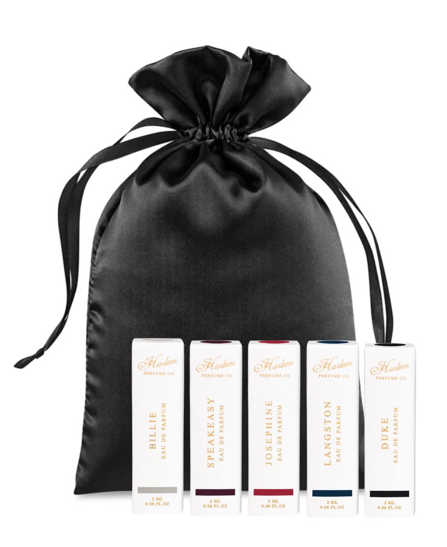 This is an image of our perfume discovery set of five fragrances to include Billie, Speakeasy, Josephine, Langston and Duke. The perfume boxes are featured in front of a black satin bag.