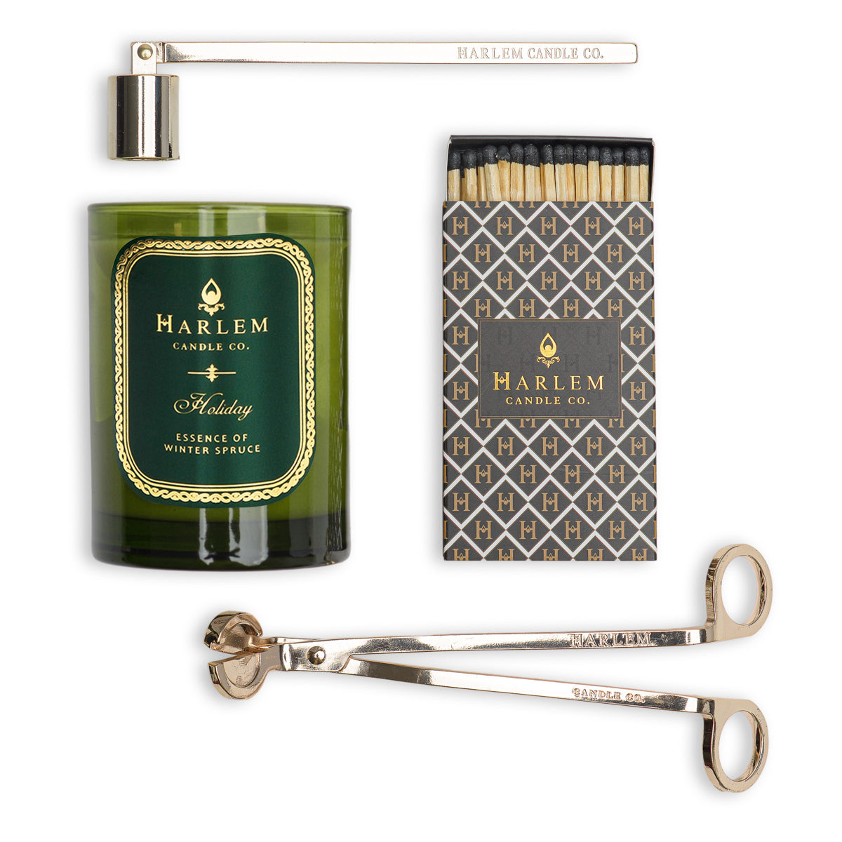 This is an image of our holiday candle featured next to the snuffer, trimmer and a set of matches in an art deco style match box.